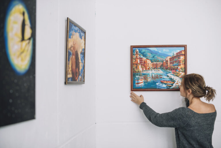 woman placing painting wall